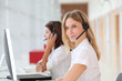© goodluz - Business people working in front of computer with headphones