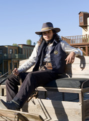 Fototapete - Sheriff sitting on a wagon on a film set