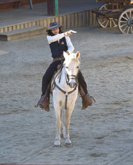 Fototapete - Sheriff shooting his gun while riding his horse