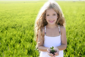 Wall Mural - sprout plant growing from little girl hands outdoo