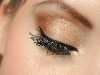 Beautiful macro shot of eye with long lashes and make-up in brow