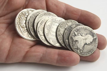 hand with ancient silver coins