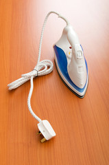 Poster - Modern electric iron on the wooden background