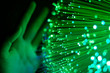 Hand touching green fiber optics