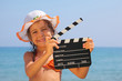 © Pavel Losevsky - girl standing on beach and holding clapboard. focus on girl eyes