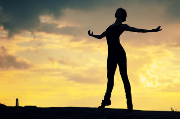 Silhouette of dancing woman over sunset. Yoga