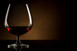 Glass of brandy over brown background