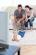 © WavebreakMediaMicro - Cute little boy watching television on the floor with his parent