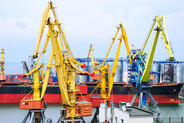 The trading seaport with cranes, cargoes and ship