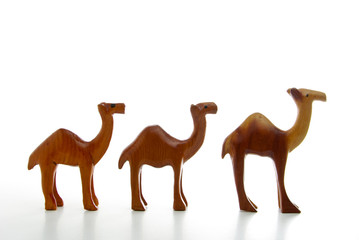 Three wooden camels isolated on a white background