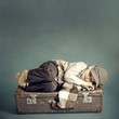 boy sleeping on a suitcase