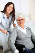 © goodluz - Elderly woman in wheelchair with nurse at home