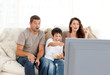 © WavebreakMediaMicro - Happy family watching a movie on television together on the sofa