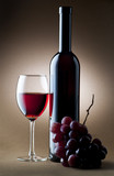Fototapeta  - glass of red wine with bottle and cluster