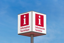 Red Lettered Tourist Information Sign Over A Blue Sky