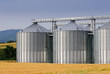 Grain store in wheatfield with hills in background
