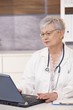 © nyul - Senior doctor using laptop