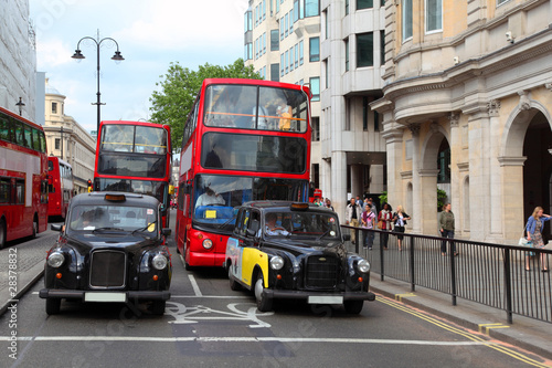 Naklejka na szybę Red double-deckers with tourists and taxi on street of London