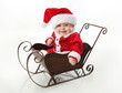 © blessings - Smiling santa baby sitting in a sleigh