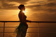 © Pavel Losevsky - woman standing on deck of cruise ship and looking away.