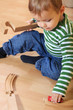 Kleinkind spielt mit Holzeisenbahn