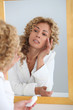© goodluz - Portrait of beautiful woman applying moisturizer