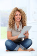 © goodluz - Woman in sofa using electronic pad