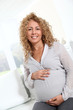 © goodluz - Smiling pregnant woman at home