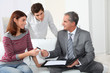 © goodluz - Young couple sigining renting contract with real estate agent