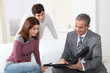 © goodluz - Young couple sigining renting contract with real estate agent