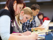 © lightpoet - pretty female college student sitting in a classroom full of stu