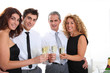 © goodluz - Group of friends cheering with glasses of champagne