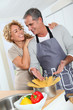 © goodluz - Happy couple preparing italian dinner at home