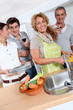 © goodluz - Group of friends prepraing dinner in home kitchen
