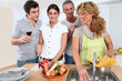 © goodluz - Group of friends prepraing dinner in home kitchen