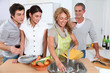 © goodluz - Group of friends prepraing dinner in home kitchen