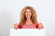 © goodluz - Funny blond woman holding whiteboard