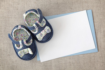 Wall Mural - Baby shoes and blank note on textile background