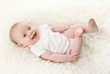 © blessings - Baby lying on back smiling with feet in the air