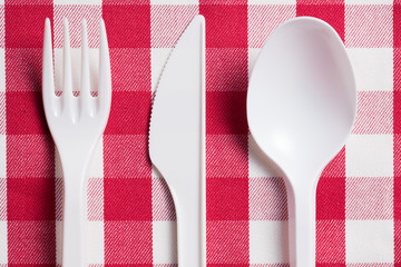 Wall Mural - plastic cutlery on checkered tablecloth