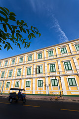 Wall Mural - yellow building with green windows beside road and tuk tuk