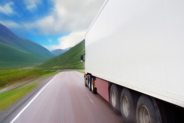 Motion of white semi-truck on the mountain road