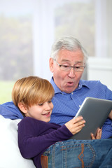 Grandpa with little boy using electronic tablet