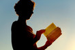 © Pavel Losevsky - young curl woman reading bible and turning page, side view
