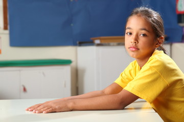 Wall Mural - Sullen schoolgirl 10 waiting at her classroom desk