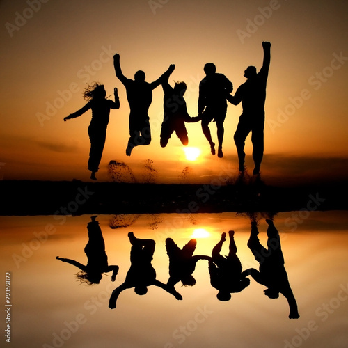 Obraz w ramie silhouette of friends jumping on beach in sunset
