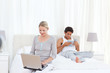 © WavebreakMediaMicro - Woman working on her laptop while her husband is reading