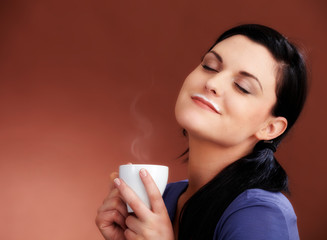 Woman with hot coffe and a rest of milk on her mouth