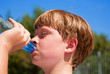 © travelview - young boy drinks water out of a bottle after sports