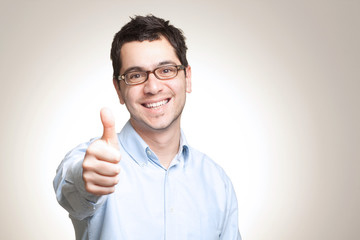 Young caucasian man with glasses showing thumbs up